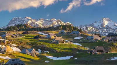 a mountain village with snow capped mountains in the background at Vacation Station Kamnik in Kamnik