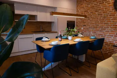 a dining room with a wooden table and blue chairs at Vacation Station Kamnik in Kamnik