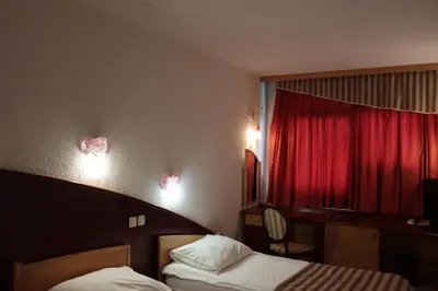 a hotel room with two beds and a red curtain at MC Hotel in Žalec