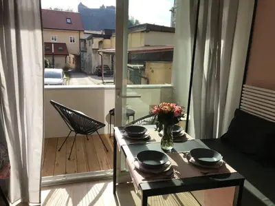a table with a vase of flowers on a balcony at Sunny home with cute dragon in the center+parking in Ljubljana