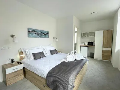 a bedroom with a large bed with white sheets at Villa Riverside in Ljubljana