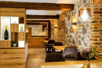 a restaurant with a brick wall and tables and chairs at Resort Village Majer - Apartments, Glamping - Slovenia in Gradac