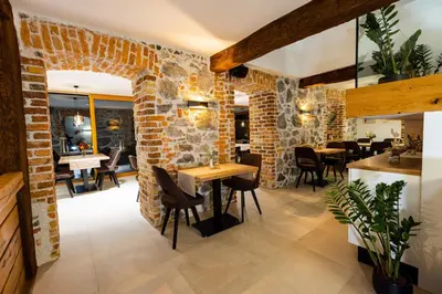 a restaurant with brick walls and tables and chairs at Resort Village Majer - Apartments, Glamping - Slovenia in Gradac