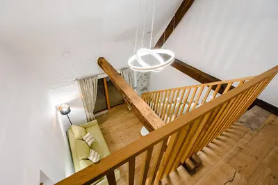 a wooden staircase with a chandelier in a room at Resort Village Majer - Apartments, Glamping - Slovenia in Gradac