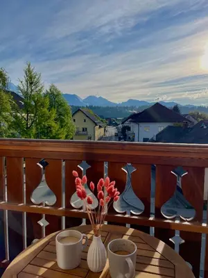 a table with vases and flowers on a balcony at Apartments Naklo in Naklo