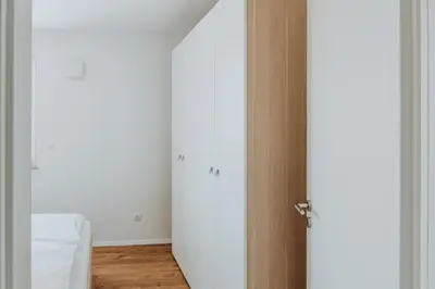 an open door to a room with white walls and wooden floors at Apartments Naklo in Naklo