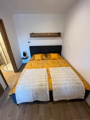 a bedroom with a large bed with a yellow and white blanket at Apartment & Studio Forest Paradise in Cerkno