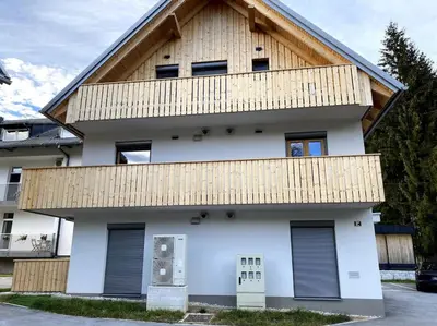 a white house with a wooden roof at Lux Apartment Ski&Golf in Kranjska Gora