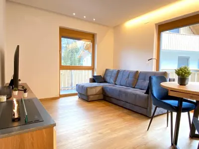 a living room with a couch and a table at Lux Apartment Ski&Golf in Kranjska Gora