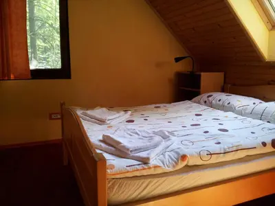 a bedroom with a bed with white sheets and a window at Apartment Lake Bohinj no. 5 in Bohinj