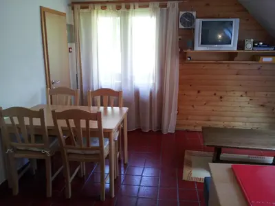 a dining room with a table and chairs and a tv at Apartment Lake Bohinj no. 5 in Bohinj
