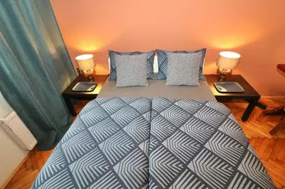 a bedroom with a large bed with two night tables at Studio City in Ljubljana