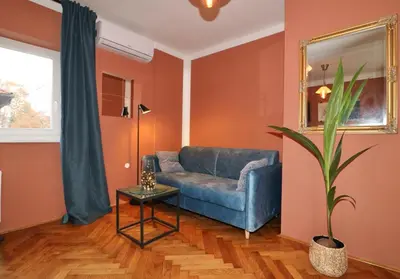 a living room with a blue couch and a table at Studio City in Ljubljana