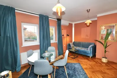 a living room with a couch and a table and chairs at Studio City in Ljubljana