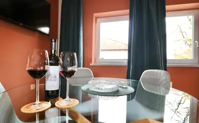 a glass table with two glasses of wine on it at Studio City in Ljubljana