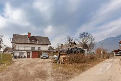 a house with a car parked in front of it at Apartma Naravni biser in Brezje