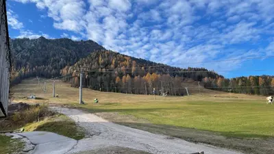 a grassy field with a mountain in the background at Apartment Katrca Kranjska Gora in Kranjska Gora