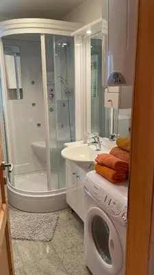 a bathroom with a shower and a washing machine at Apartment Katrca Kranjska Gora in Kranjska Gora