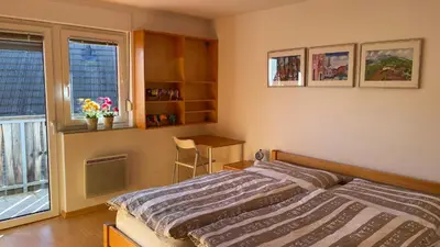 a bedroom with a bed and a desk and a window at Apartment Katrca Kranjska Gora in Kranjska Gora