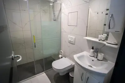 a bathroom with a toilet and a sink and a shower at Villa Magdalena apartments & rooms GARNI HOTEL in Maribor