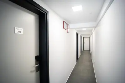 a hallway with white walls and a door at Villa Magdalena apartments & rooms GARNI HOTEL in Maribor