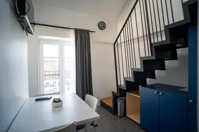 a room with a staircase with a white table and a blue cabinet at Villa Magdalena apartments & rooms GARNI HOTEL in Maribor