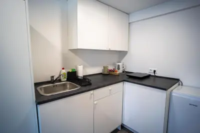 a kitchen with white cabinets and a sink at Villa Magdalena apartments & rooms GARNI HOTEL in Maribor