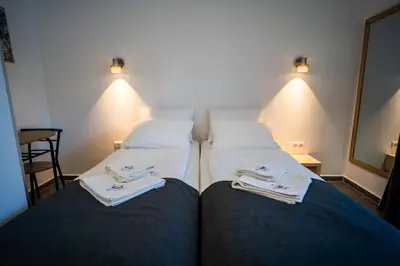 two beds in a hotel room with towels on them at Villa Magdalena apartments & rooms GARNI HOTEL in Maribor