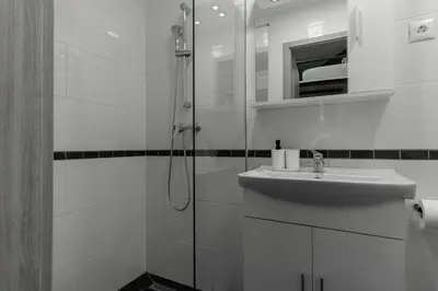 a white bathroom with a shower and a sink at Apartments Park Vodice - Ljubljana, Krvavec in Woditz