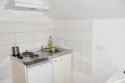a white tiled kitchen with a sink and a stove at Apartments Park Vodice - Ljubljana, Krvavec in Woditz