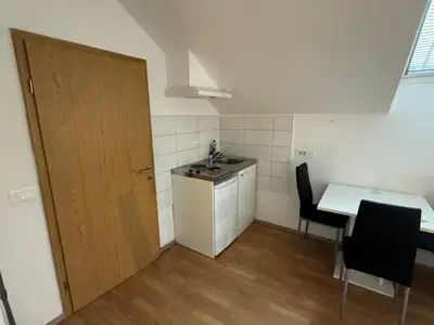 a small kitchen with a table and a door at Apartments Park Vodice - Ljubljana, Krvavec in Woditz