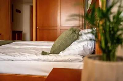 a green chair sitting on top of a bed at LAGOJA b&b in Trzin