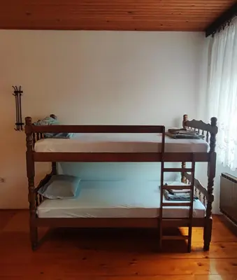 two bunk beds in a room with a window at Family Hostel Pivka in Pivka