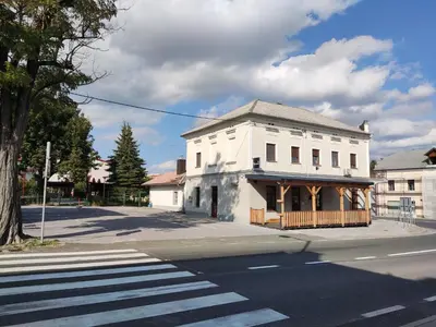 an old white building on the corner of a street at Family Hostel Pivka in Pivka