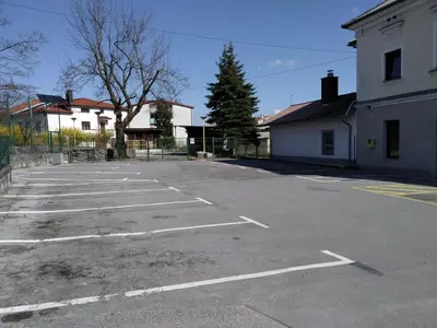 an empty parking lot in front of a building at Family Hostel Pivka in Pivka