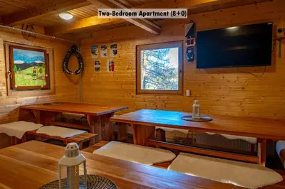 a room with a table and a tv in a cabin at Apartments Farm House Uric in Jesenice