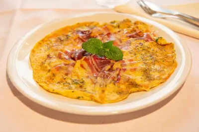 a pizza on a white plate on a table at Tourist Farm Škerlj in Dutovlje