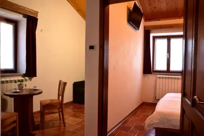 a room with a bed and a table and window at Tourist Farm Škerlj in Dutovlje