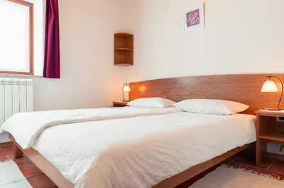 a bedroom with a large bed with a wooden headboard at Tourist Farm Škerlj in Dutovlje
