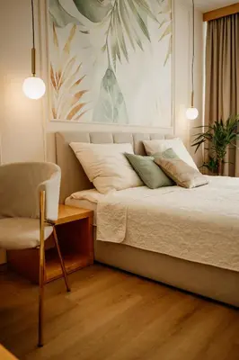 a bedroom with a bed and a chair in it at Hotel Jeruzalem in Ljutomer