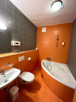 a bathroom with a tub and a toilet and a sink at Hotel Jeruzalem in Ljutomer