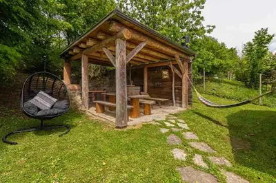 a wooden gazebo with a bench in the grass at Holiday home in Novo mesto - dostava - Kranjska Krain 26036 in Trška Gora