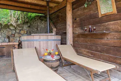a porch of a wooden cabin with two benches at Holiday home in Novo mesto - dostava - Kranjska Krain 26036 in Trška Gora