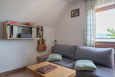 a living room with a couch and a table and a guitar at Holiday home in Novo mesto - dostava - Kranjska Krain 26036 in Trška Gora
