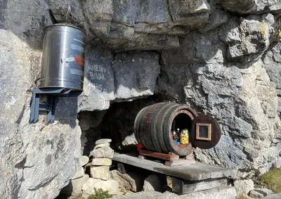 a barrel and a bucket in a stone wall at Golte Apartment Tibona in Mozirje
