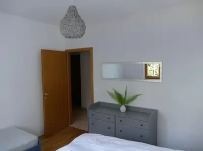 a bedroom with a bed and a dresser and a mirror at Forest Green Pohorje Apartment in Pohorje