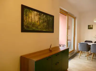 a living room with a painting hanging on the wall at Forest Green Pohorje Apartment in Pohorje