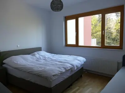 a bedroom with a bed and a window at Forest Green Pohorje Apartment in Pohorje