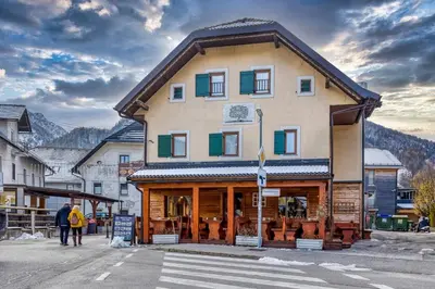 a building with people walking in front of it at Country House Viktor in Kranjska Gora