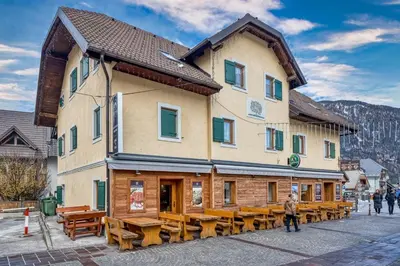 a building with wooden tables and benches in front of it at Country House Viktor in Kranjska Gora